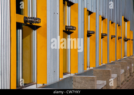 Eine Reihe von zurückweichenden gelben Fensterrahmen auf ein Gebäude mit Metall Abstellgleis, Granville Island, Vancouver, Kanada Stockfoto