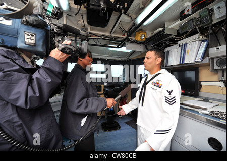 Der Techniker der 1. Klasse von Electronic Luis Carrasco beantwortet Fragen der lokalen Medien an Bord des Küstenpatrouillenschiffs USS Hurricane (PC 3) der Cyclone-Klasse während der Kriegsfeier der Marine zum 200. Jahrestag des Krieges von 1812 in Milwaukee. Diese Feier fällt mit der Milwaukee Navy Week zusammen, einer von 15 Signature Events, die 2012 in ganz Amerika geplant sind. Die einwöchige Veranstaltung erinnert an den 200. Jahrestag des Krieges von 1812, bei der Mitglieder der US-Marine, des Marine Corps, der Küstenwache und der Royal Canadian Navy zu Gast sind. Stockfoto