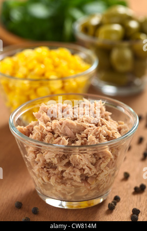 Thunfisch in Dosen in Glasschale mit frischem Salatzutaten (Mais, grünen Oliven und Kresse) in den Rücken Stockfoto