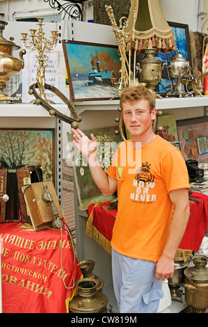 Der Mann steht in der Nähe von antiquarischen Dinge des letzten Jahrhunderts und in einer Hand hält alte Tamburin. Stockfoto