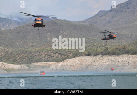 Zwei UH-60 Black Hawks von Alpha Company, 2. Bataillon, 285. Luftfahrtregiment der Arizona National Guard, tauchen in Bartett Lake ein und füllen bambi Eimer während der Brandbekämpfung am 14. August. Die Flieger unterstützten die staatlichen und nationalen Forstabteilungen bei der Bekämpfung des Charley-Feuers in der Nähe des Bartlett Lake und des Mistake Peak-Feuers in der Nähe des Roosevelt Lake. Es wird erwartet, dass die Besatzungen die Arbeit an den beiden Bränden bis zum Rest der Woche und möglicherweise bis in die nächste Woche fortsetzen werden. Stockfoto