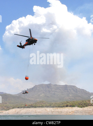 Zwei UH-60 Black Hawks von Alpha Company, 2. Bataillon, 285. Luftfahrtregiment der Arizona National Guard, tauchen in Bartett Lake ein und füllen bambi Eimer während der Brandbekämpfung am 14. August. Die Flieger unterstützten die staatlichen und nationalen Forstabteilungen bei der Bekämpfung des Charley-Feuers in der Nähe des Bartlett Lake und des Mistake Peak-Feuers in der Nähe des Roosevelt Lake. Es wird erwartet, dass die Besatzungen die Arbeit an den beiden Bränden bis zum Rest der Woche und möglicherweise bis in die nächste Woche fortsetzen werden. Stockfoto