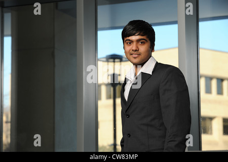 Junge indische Geschäftsmann aufstehen von einem Büro-Fenster Stockfoto