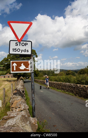 Stop-Schild, und Touristische Informationen Hexe auf Besen. Am Straßenrand Witchway marker Land Zeichen in der Nähe von Pendle, Roughlee, Lancashire, Großbritannien Stockfoto