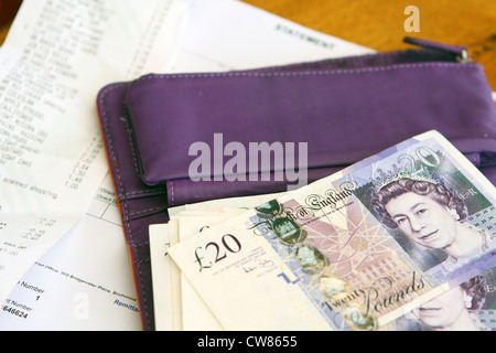 gute Noten und eine offene Tasche liegen auf Rechnungen und Quittungen Stockfoto