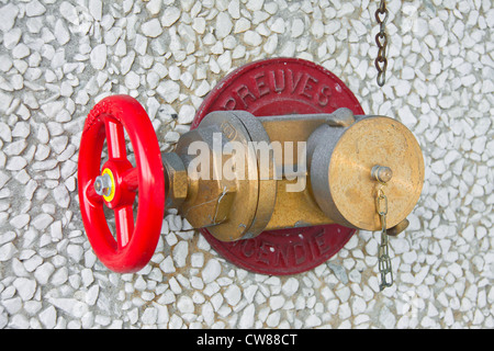 Kupfer Hydrant mit einem Ventil mit Grünspan gegen eine weiße Steinmauer Stockfoto