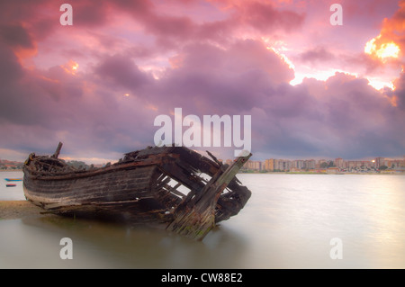 Nach längerer Zeit ruht das alte Boot am Ufer Flusses Stockfoto