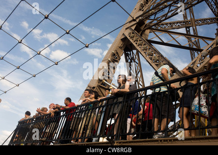 Touristen Sehenswürdigkeiten hinweisen und Paris unterhalb von der zweiten Etage des Eiffelturms zu bewundern. Stockfoto