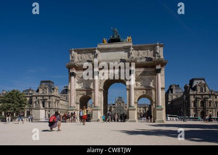 Touristen und der Arc de Triomphe de Carrousel außerhalb des Louvre in Paris. Der Bogen ist ein Triumphbogen in Paris, befindet sich in der Place du Carrousel auf dem Gelände des ehemaligen Tuilerien-Palast. Es entstand zwischen 1806 und 1808 Napoleons militärische Siege des Vorjahres zu gedenken. Das Denkmal ist 63 Fuß (19 m) hoch, 75 Fuß (23 m) breit und 24 Fuß (7,3 m) tief. Stockfoto