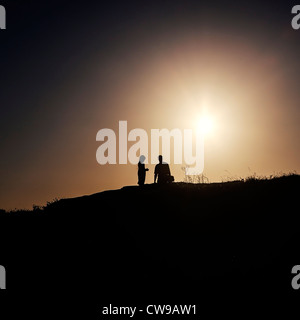 zwei Menschen stehen auf der Rückseite Leuchten auf einem Hügel Stockfoto