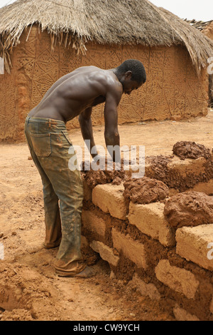 Mann, die Lehmziegel-Hausbau in Mognori Öko-Dorf, Ghana Stockfoto