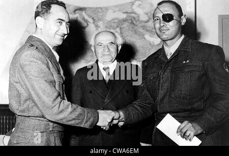 Israelischer General Moshe Dayan (rechts) schüttelt Hände mit General Mordechai Marcleff. Premierminister David Ben-Gurion blickt auf, Stockfoto