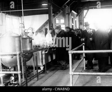 Männer warten in der Schlange für Lebensmittel an eine kommunale Herberge. Polizeichef Edward P. Mulrooney steht mit Kaffee (zweiter von Stockfoto