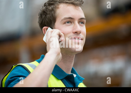 Mann am Handy im Warehouse, Porträt Stockfoto