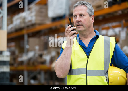 Mann auf Walkie-Talkie im Lager Stockfoto