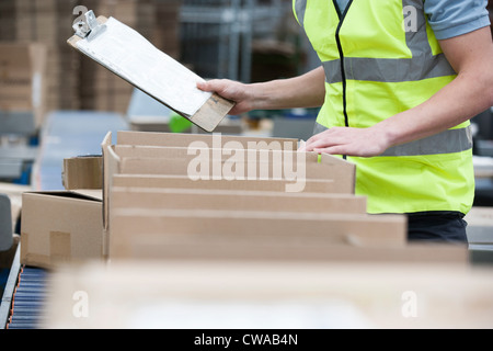 Mann mit Zwischenablage Lager prüfen Stockfoto