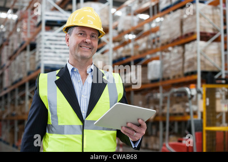 Mann mit digital-Tablette in Lager, Porträt Stockfoto