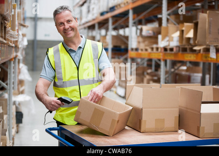 Mann mit Barcode-Lesegerät im Lager Stockfoto