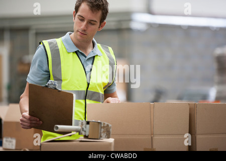 Mann überprüfen Kartons Stockfoto