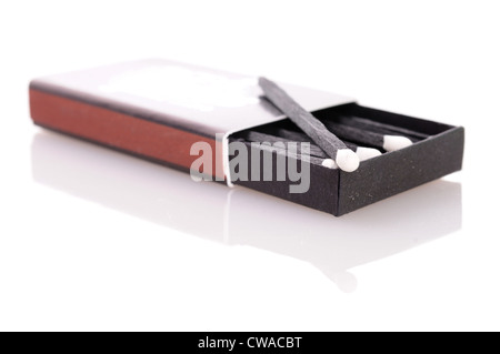 Streichholzschachtel mit stilvollen schwarzen Übereinstimmungen mit weißen Köpfen. Nahaufnahme mit Fokus auf das Streichholzkopf. Isoliert auf weißem Hintergrund. Stockfoto