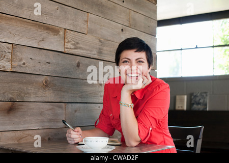 Frau trägt rotes Hemd sitzen im Café, Porträt Stockfoto