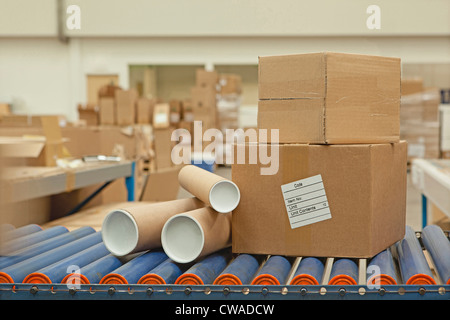 Kartons und Rohre auf Förderband Stockfoto