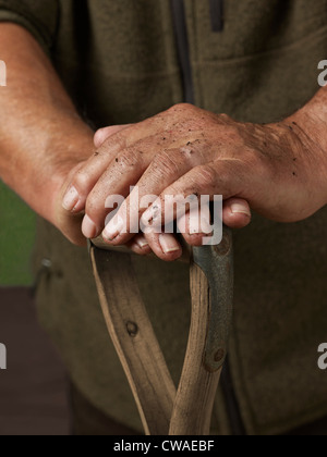 Mann mit Händen stützte sich auf Holzgriff Stockfoto