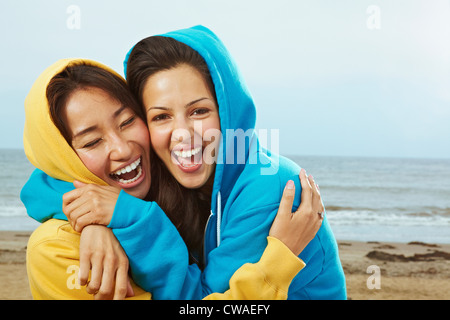 Zwei junge Frauen in mit Kapuze Spitzen am Strand Stockfoto