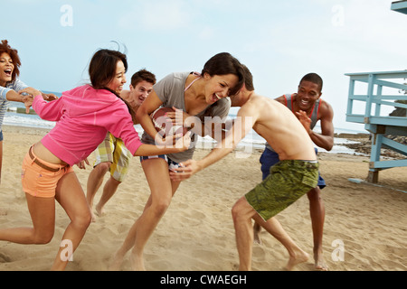 Freunde am Strand Rugby zu spielen Stockfoto