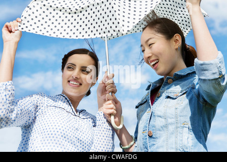 Zwei junge Frauen im Freien mit Sonnenschirm Stockfoto