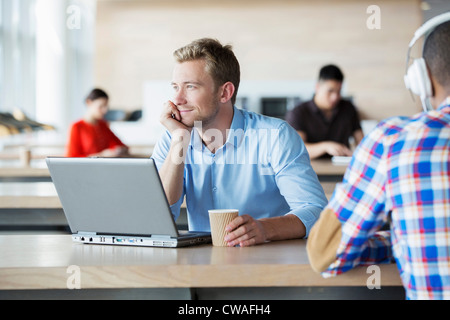 Junger Mann im Pausenraum mit laptop Stockfoto