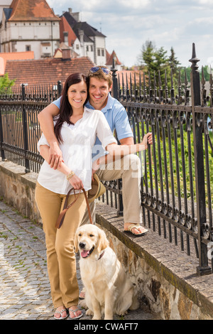 Junges Paar mit Hund posiert auf historische Stadt Sonnentag Stockfoto