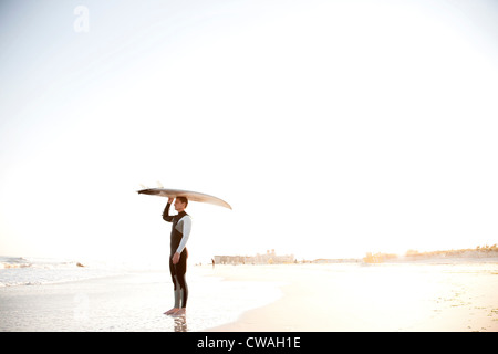 Surfer mit Surfbrett auf Kopf Stockfoto