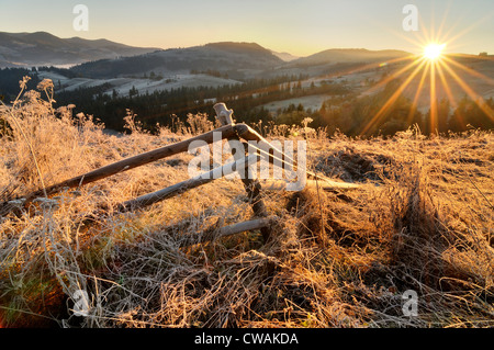 Zaun und Sonnenaufgang am frostigen Morgen gebrochen Krasnik Dorf Bereich, Karpaten, Iwano-Frankowsk Gebiet, Ukraine Stockfoto