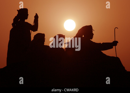 Dubai, arabische Männer in der Wüste bei Sonnenuntergang Stockfoto