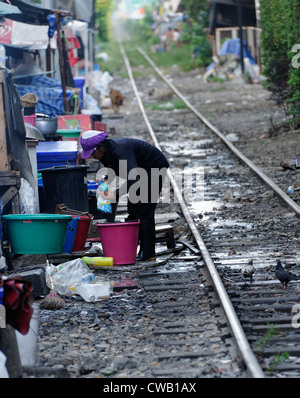 Frau waschen Geschirr in Hawker Food Stände Linie der Bahngleise durch das Zentrum auf Bangkok, Thailand Stockfoto