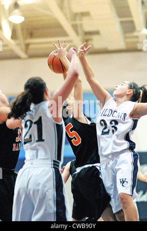 Basketball shooter vermeidet Verteidigung Girls High School Spiel zu schießen. USA. Stockfoto