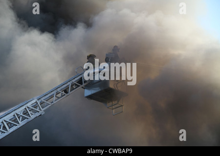 Highland Park Feuerwehr Hubarbeitsbühne gießen Wasser auf freie kommerzielle Gebäudebrand Highland Park, Michigan USA Stockfoto