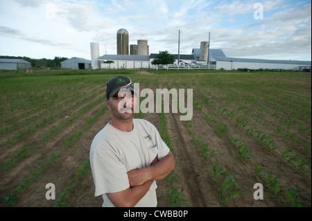 Landwirt vor Ackerland vor Scheunen und Silos Stockfoto