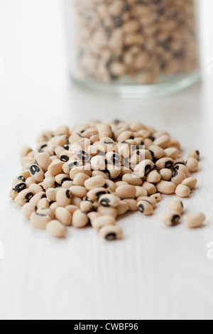 Nahaufnahme von einem Haufen von Augentrockenheit schwarze Bohnen, Glas-Container auf dem Hintergrund Stockfoto