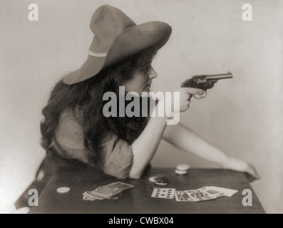 Cowgirl mit Deck von Karten und Chips, zeigt eine Pistole. 1912. Stockfoto