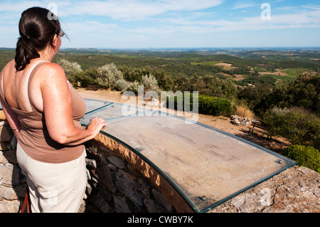 Ein Tourist mit Blick auf das Mittelmeer vom oberen Rand einer alten Windmühle in der Nähe von Faugères im Naturpark Haut-Languedoc. Stockfoto