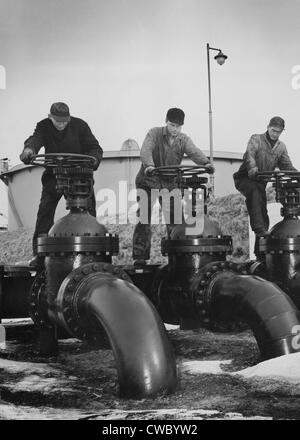 Männer dreht die Räder, große Ventile, die den Fluss des Öls in Öltankern auf ein US-Atlantik Küste Seehafen zu regulieren. Ca. 1944. Stockfoto