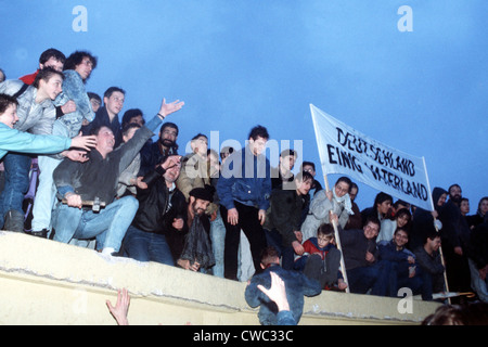 Eine Menschenmenge feiert auf der Berliner Mauer nach der offiziellen Eröffnung des Brandenburger Tores am 22. Dezember 1989. Stockfoto