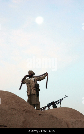 Eine Anti-Taliban-Kämpfer umschließt einen Patronengürtel Kalaschnikow Maschinengewehr Munition um seinen Körper. Der Provinz Helmand 1.Jänner 2002., Stockfoto