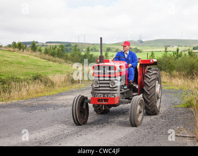 Führen Sie einen roten Oldtimer Massey Ferguson 165 Traktor zu fahren, während ein Ayrshire Oldtimer Traktor und Maschine Club Road Enthusiasten Stockfoto