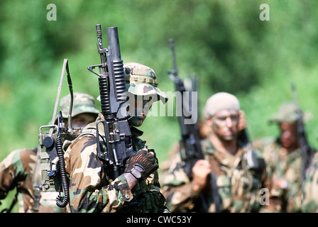 U.S. Navy SEALs an. Vordergrund Siegel trägt einen Feld-Radio und eine Colt Commando-Sturmgewehr ausgerüstet mit einem Stockfoto