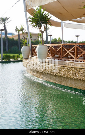 Terrasse auf dem Wasser mit einem hölzernen Geländer und dekorative Palmen Stockfoto