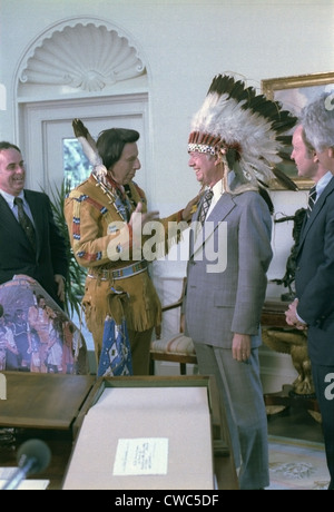 Präsident Jimmy Carter trägt einen Federschmuck, ihn vom "Iron Eyes" Cody 1904-1999 vorgelegt, ein Schauspieler und ein selbst Stockfoto