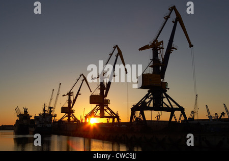 Wismar - Hafenkraene und Kais über Hafen bei Sonnenuntergang Stockfoto